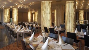 A spacious dining area with multiple tables set for service, each with a white napkin cone, silverware, and wine glasses. - Wellness Hotel Sotelia (Podcetrtek)