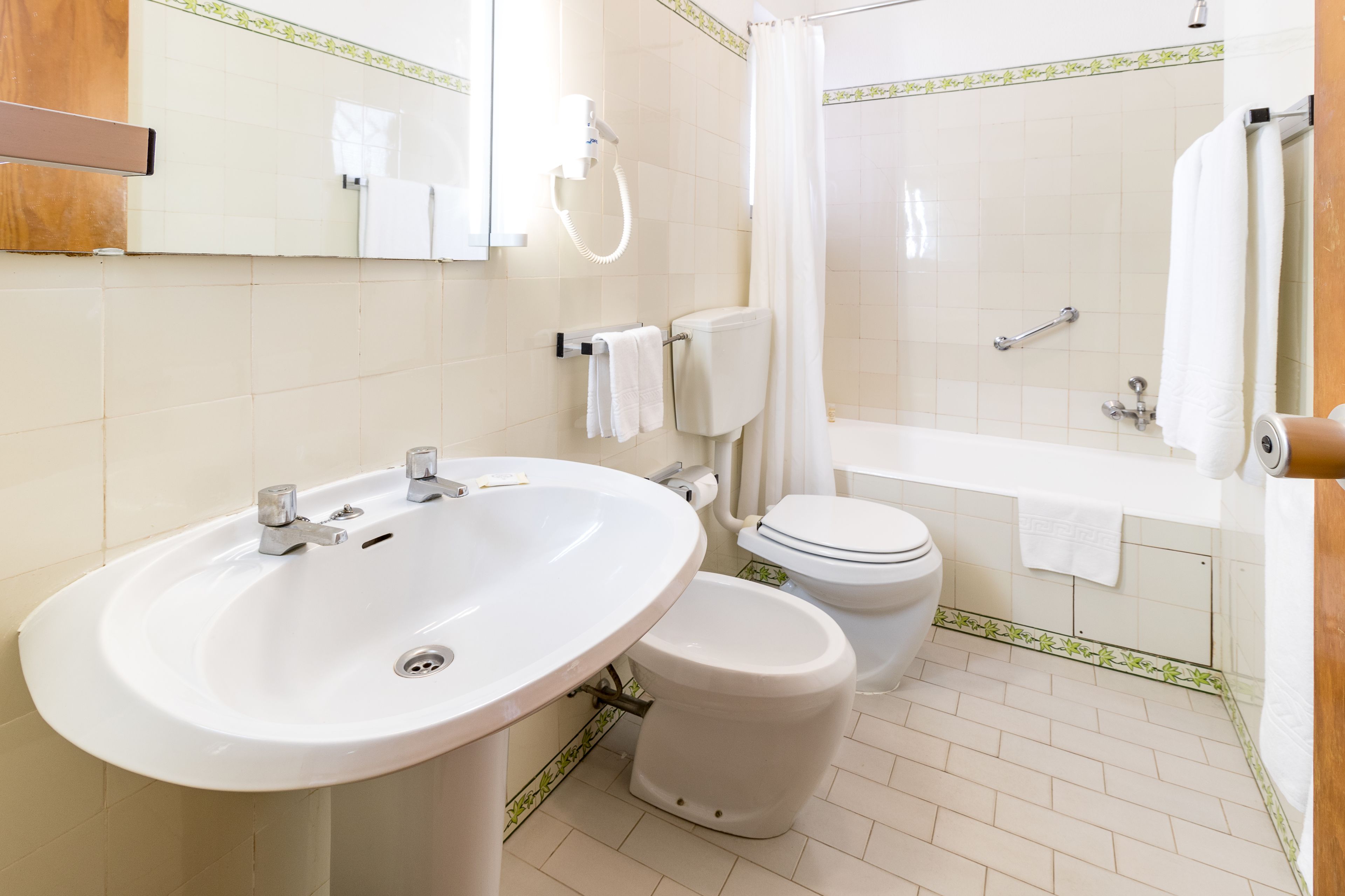 A bathroom with a sink, toilet, and bathtub.
