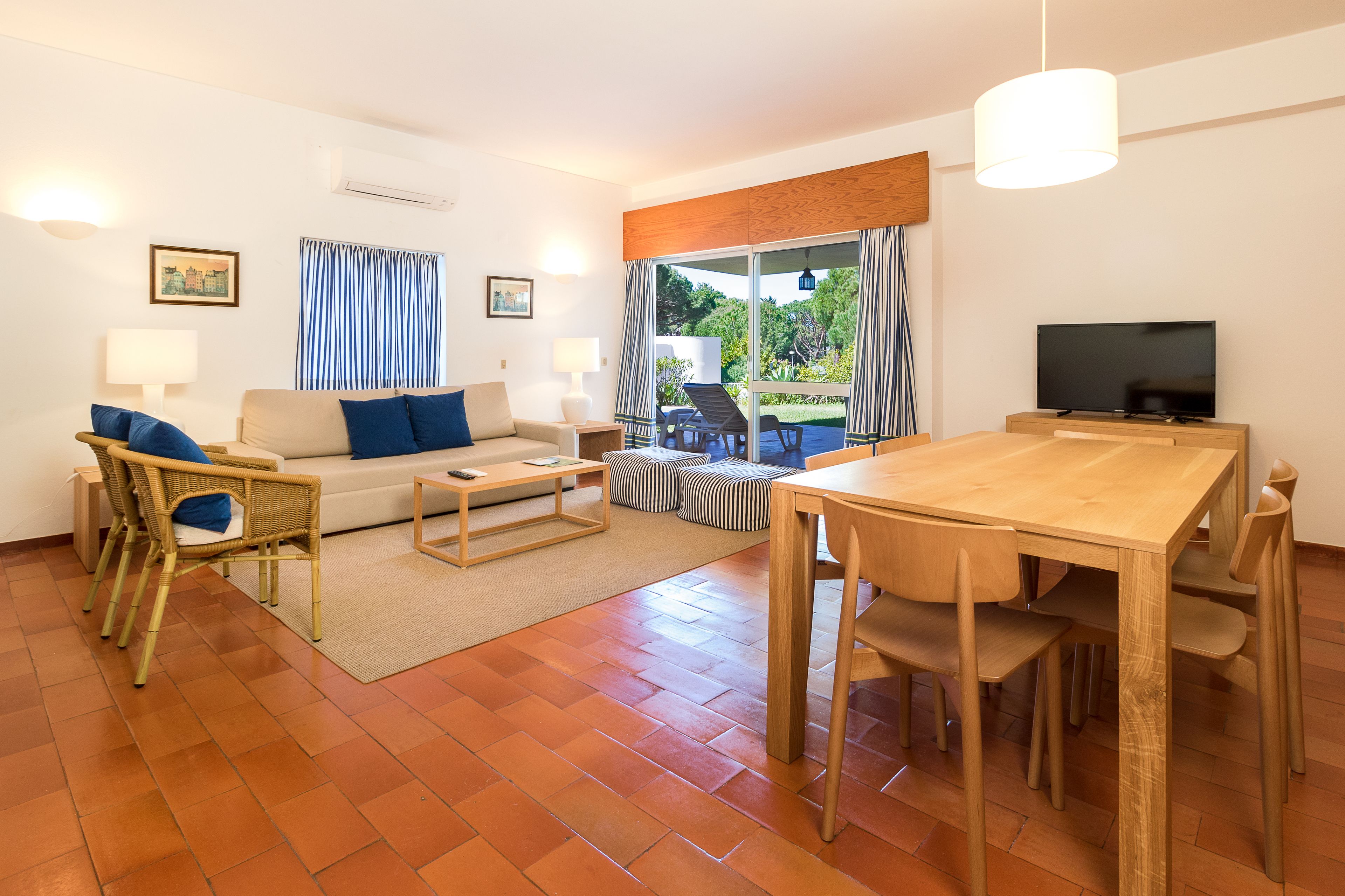 Una sala moderna con un sofá, una mesa de comedor y un televisor.