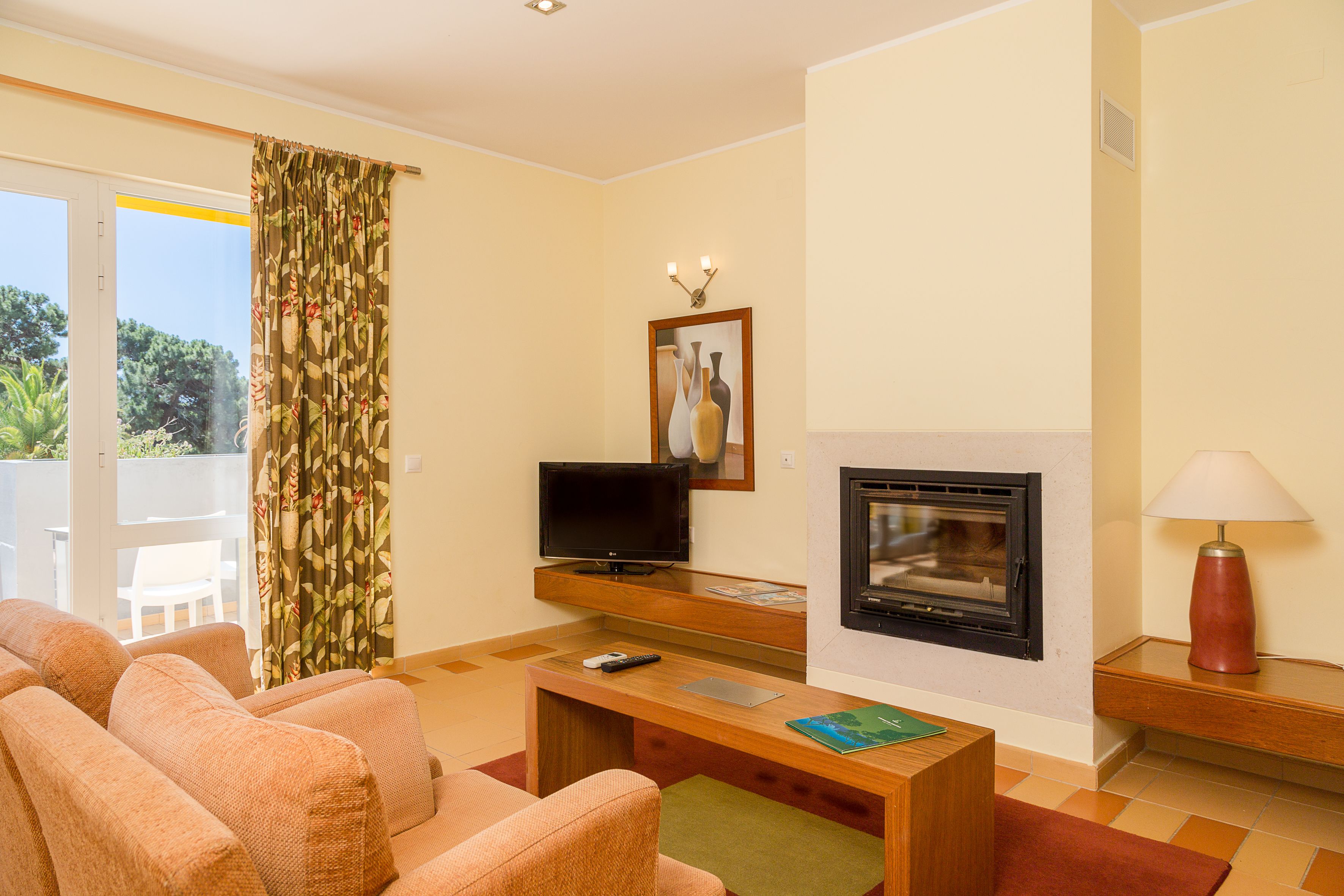 A living room with a fireplace, a television, and a sofa.