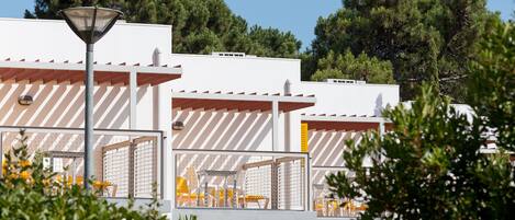 A modern building with multiple white structures, each with a sloped roof and a balcony.