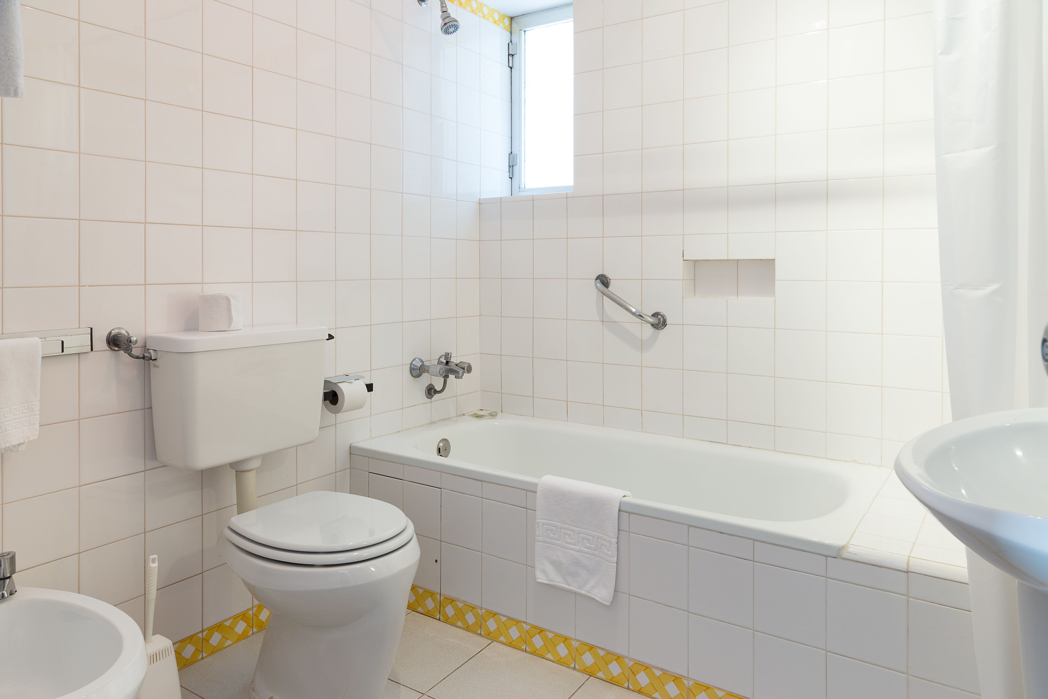 A bathroom with a toilet, sink, bathtub, and shower.