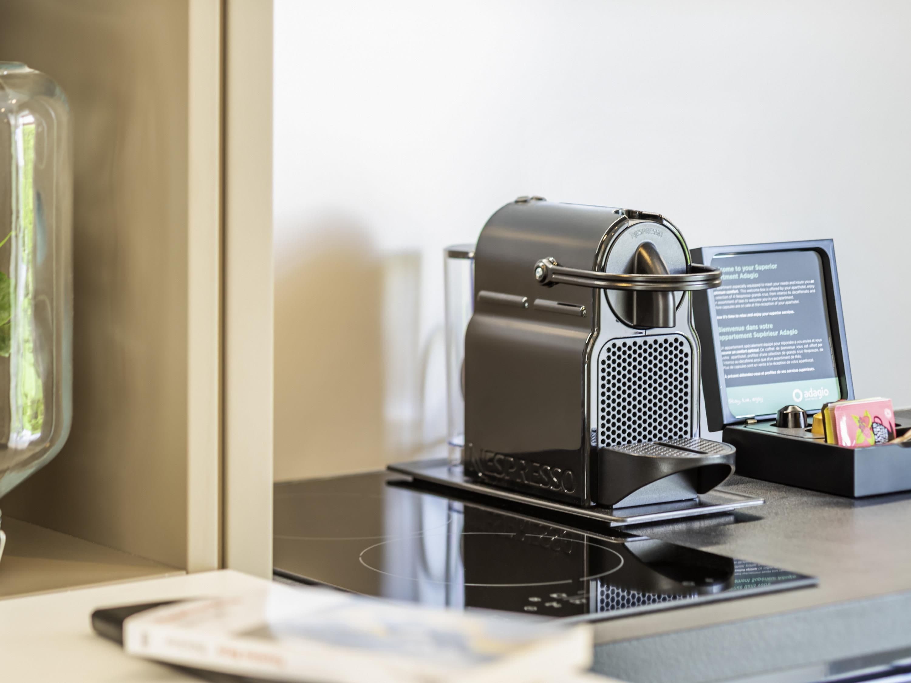 A coffee machine on a counter with a menu stand beside it.