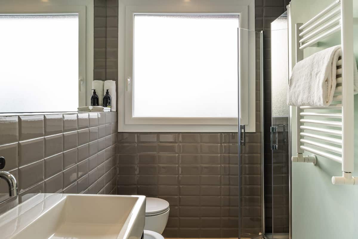 A bathroom with a large bathtub, a toilet, and a glass shower enclosure.