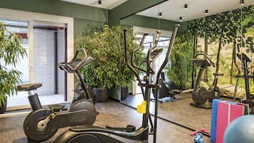 A gym with stationary bikes, elliptical machines, and free weights.