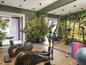 A gym with stationary bikes, elliptical machines, and free weights.