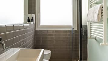 Ein Badezimmer mit einer großen Badewanne, einer Toilette und einer Duschkabine aus Glas.