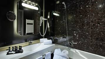 Un baño moderno con lavamanos, espejo y ducha blancos.