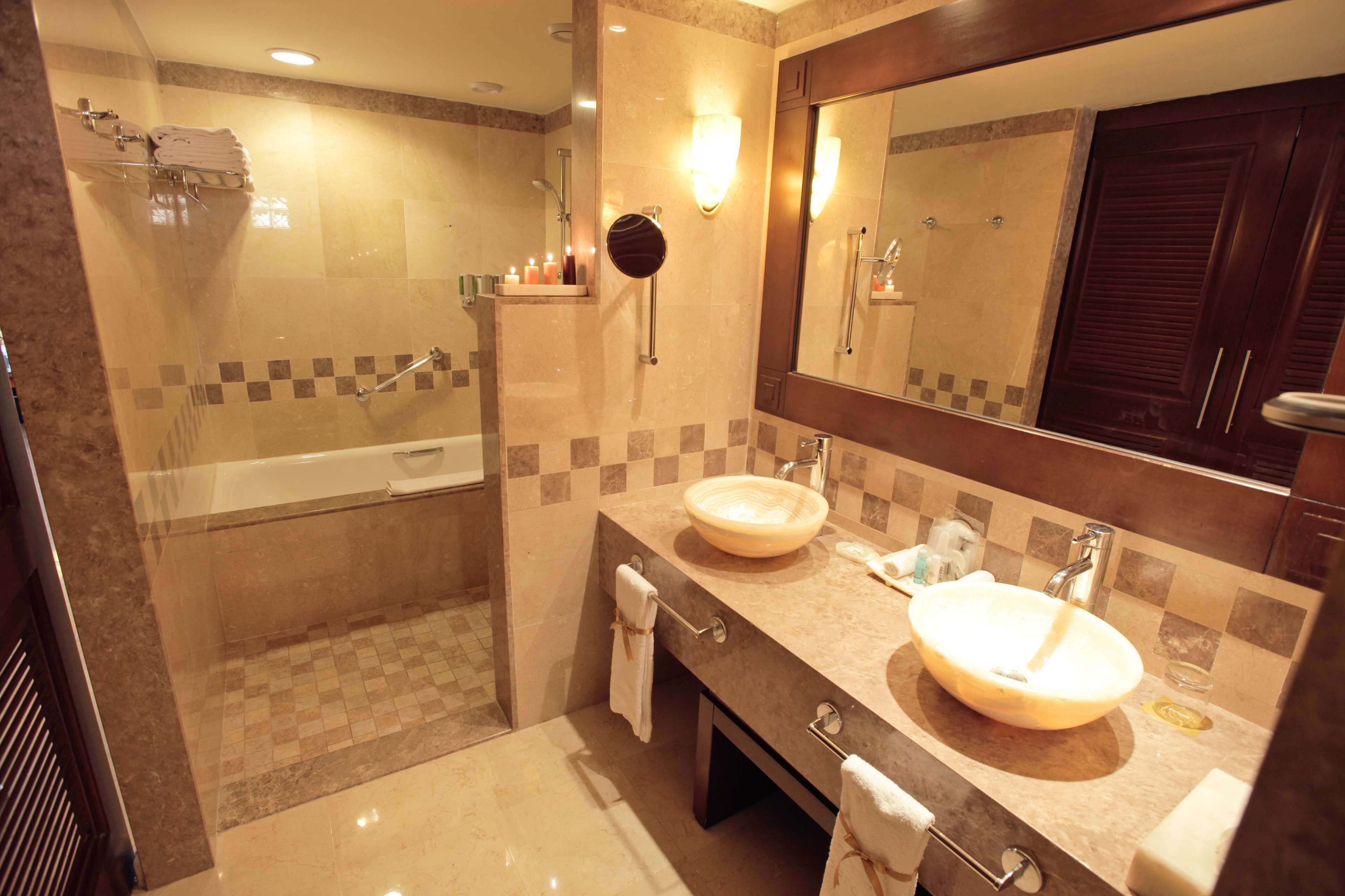Une salle de bain moderne avec une baignoire, deux lavabos, un grand miroir et un espace douche.