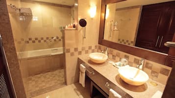 Une salle de bain moderne avec une baignoire, deux lavabos, un grand miroir et un espace douche.