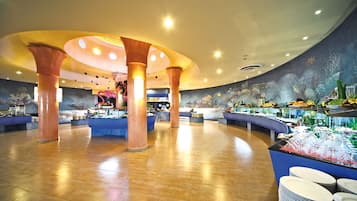 Eine geräumige Lobby mit einer zentralen Insellounge, verschiedenen Sitzbereichen und einer dekorativen Decke.