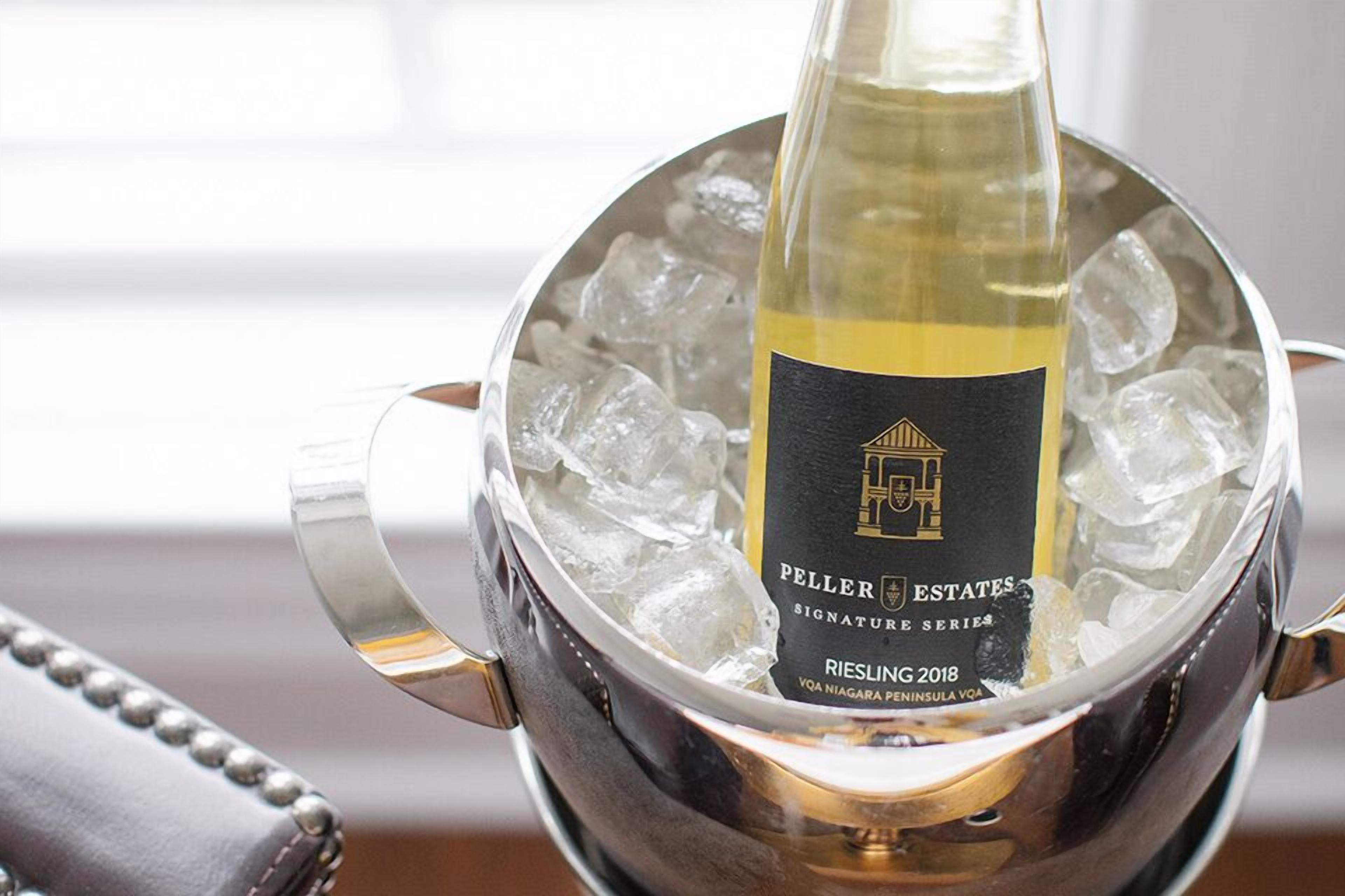 Una botella de Riesling 2018 en un balde de hielo metálico.