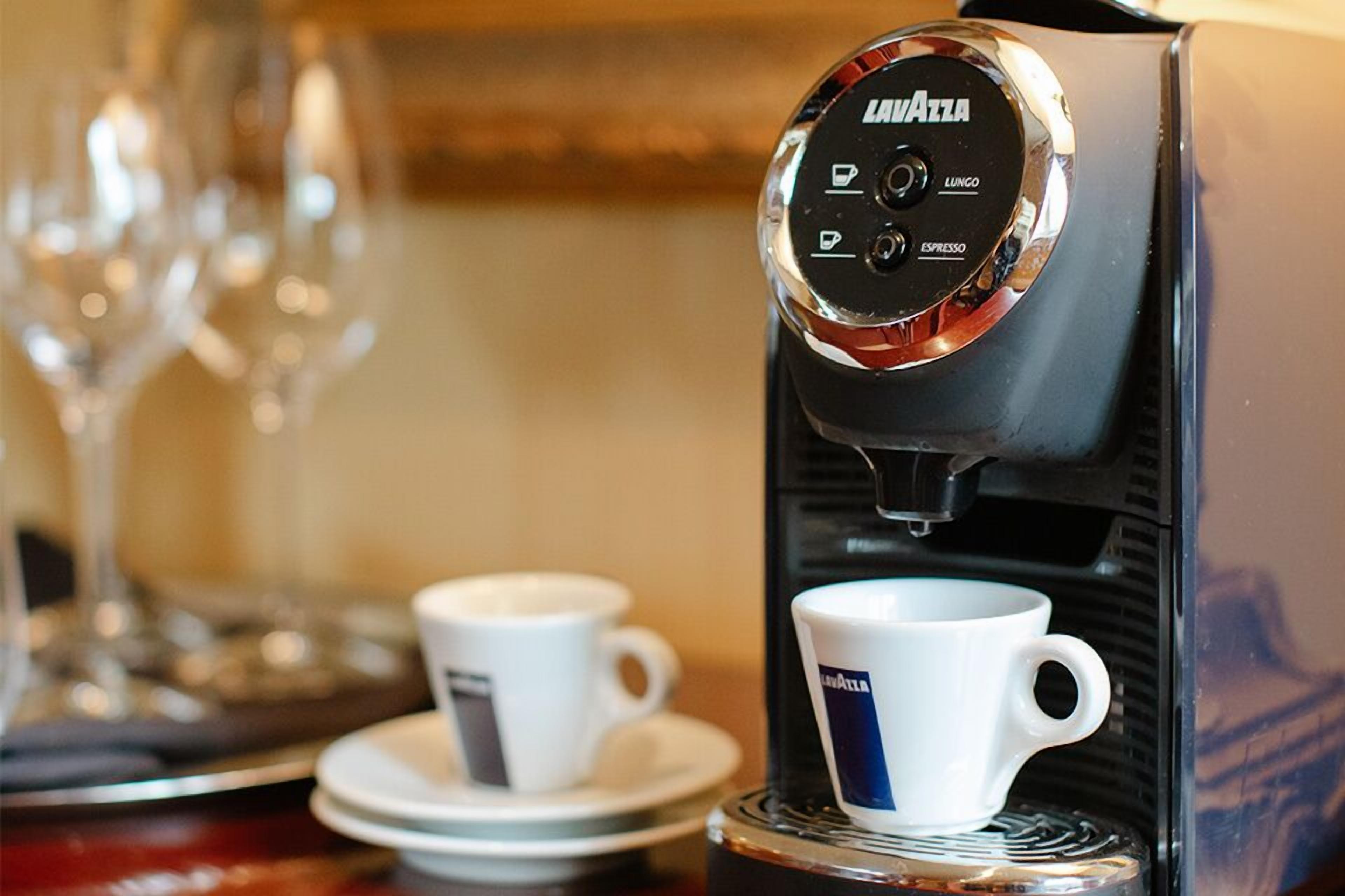 A coffee machine with options for espresso and lungo, and two cups placed on the counter.