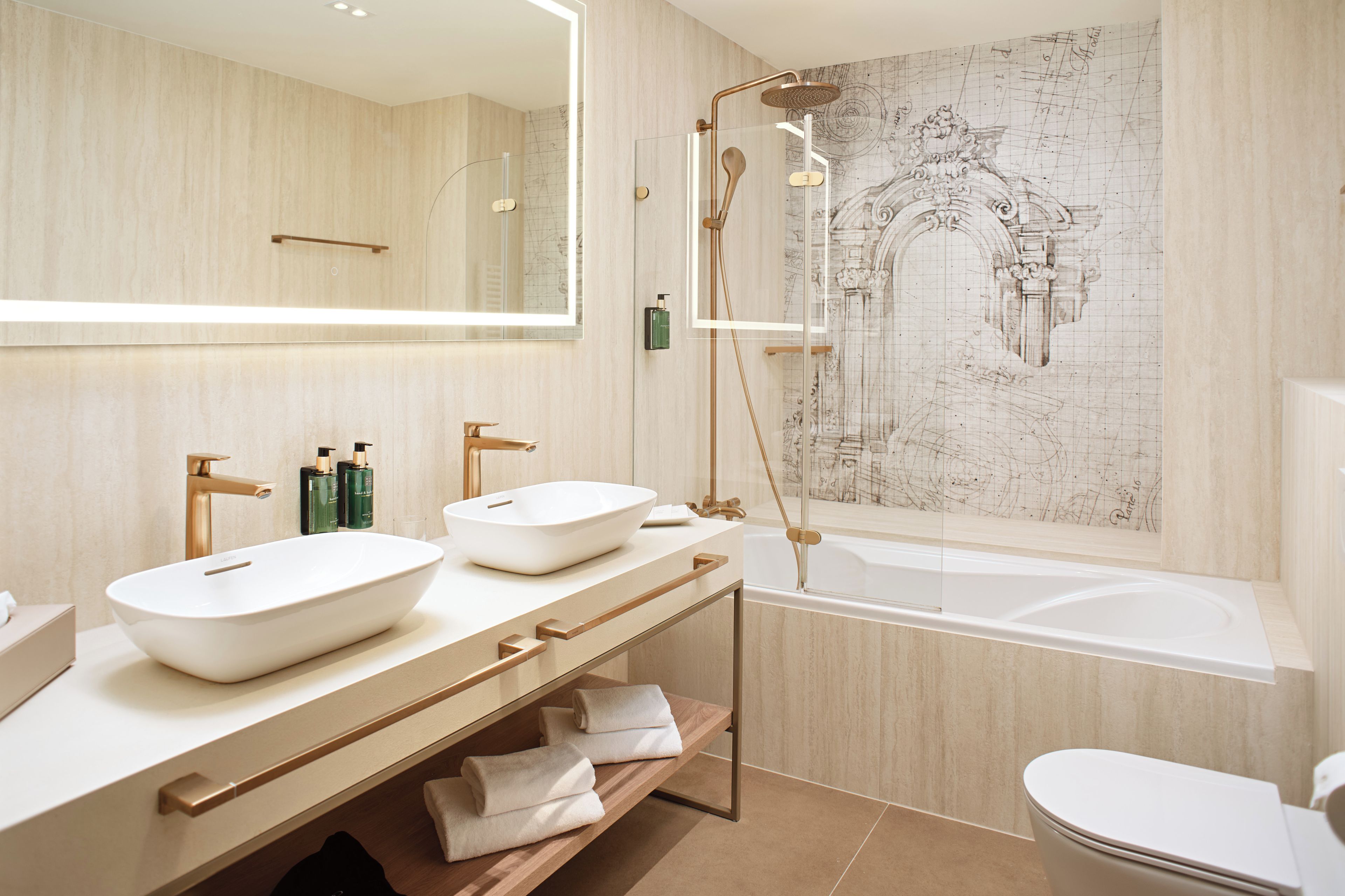 Een moderne badkamer met twee wastafels, een bad en een grote spiegel.