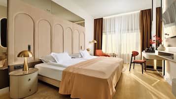Una habitación de hotel moderna con una cama grande, un escritorio y una silla.