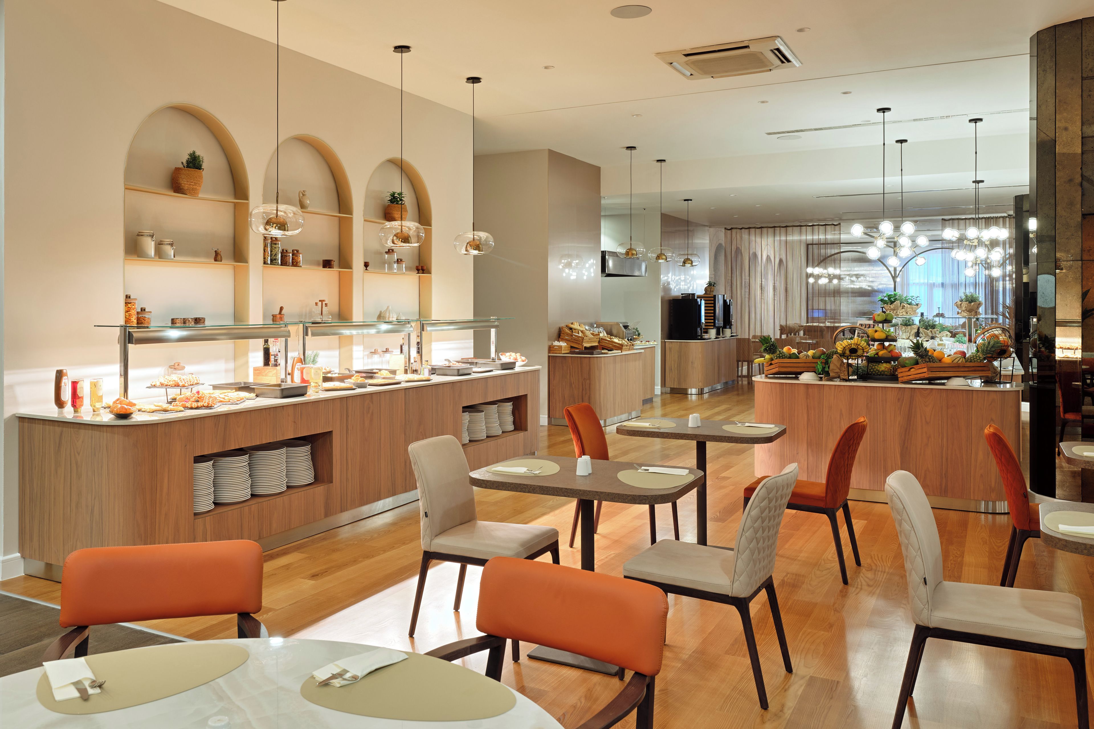 Un restaurante moderno con una barra central, varias zonas de estar y una amplia variedad de comida y bebidas.