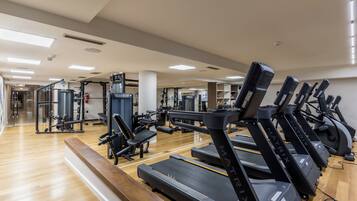A gym with treadmills, weight machines, and free weights.