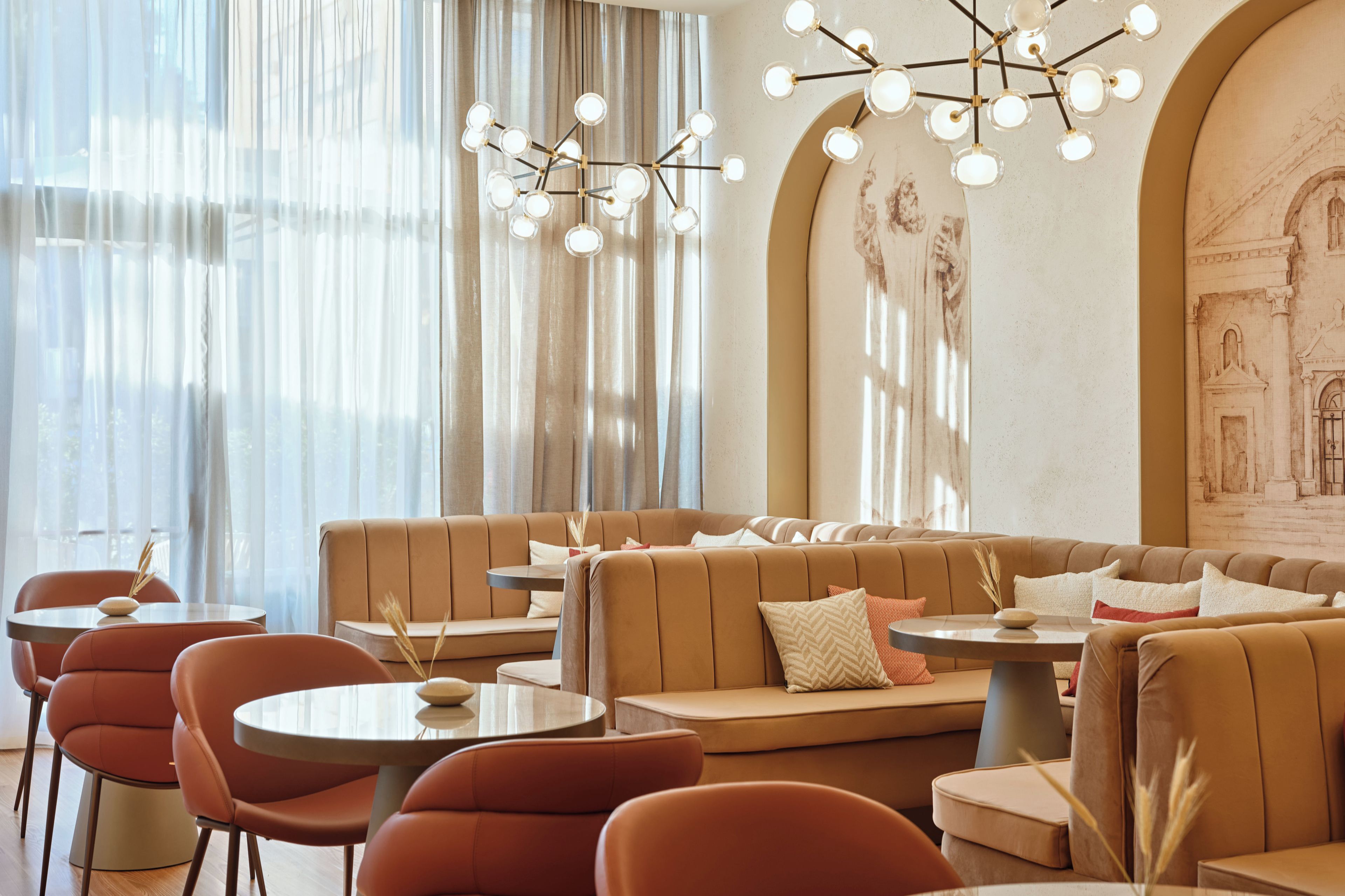 A modern interior with a seating area, tables, and a decorative light fixture.