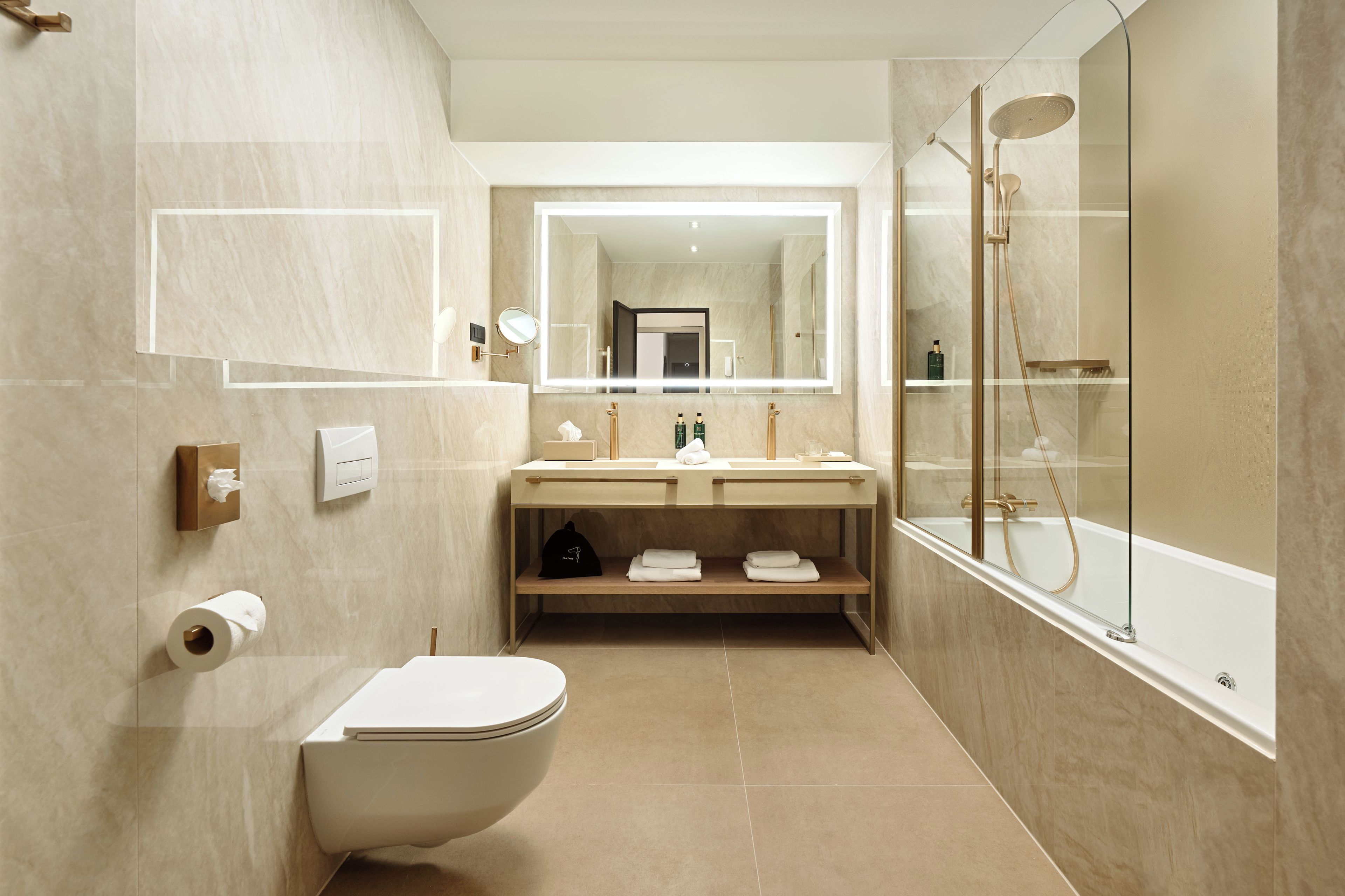 A modern bathroom with a toilet, sink, and shower.