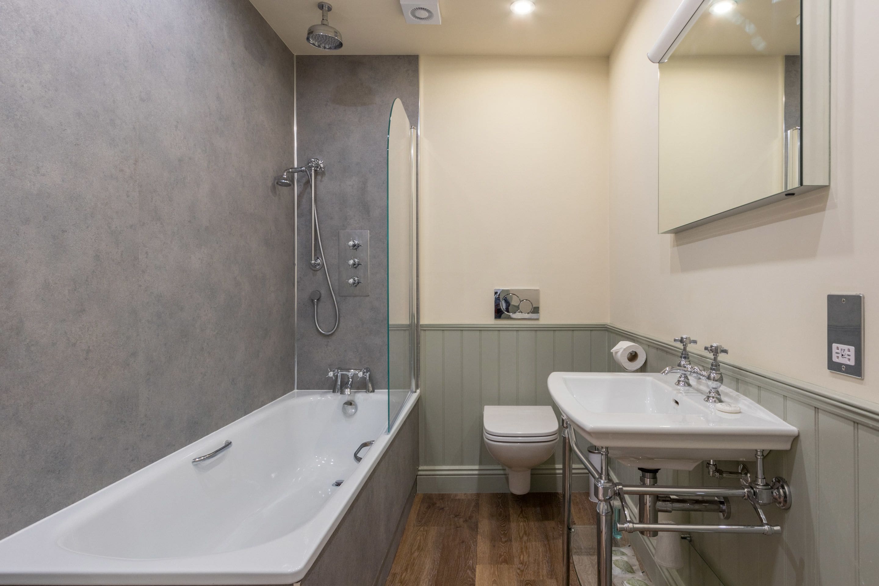 Un baño moderno con una bañera independiente, un inodoro y un lavabo con espejo.