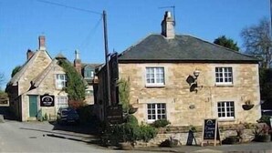 A traditional stone building with a pitched roof, multiple windows, and a signboard. - The Noel at Whitwell (Oakham)
