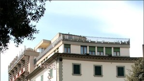 Un hôtel au style architectural classique, avec un rez-de-chaussée doté d’une grande entrée et d’une enseigne de restaurant bien visible.