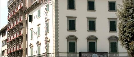 A hotel with a classic architectural style, featuring a ground floor with a large entrance and a visible restaurant sign.