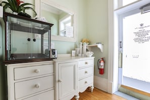 A white dresser with drawers, a glass-front cabinet, and a mirror above it.