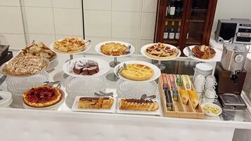 Une table de buffet proposant divers desserts, avec une sélection de vins en arrière-plan.