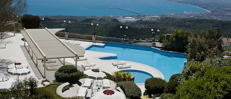 Een seizoensgebonden buitenzwembad en parasols bij het zwembad