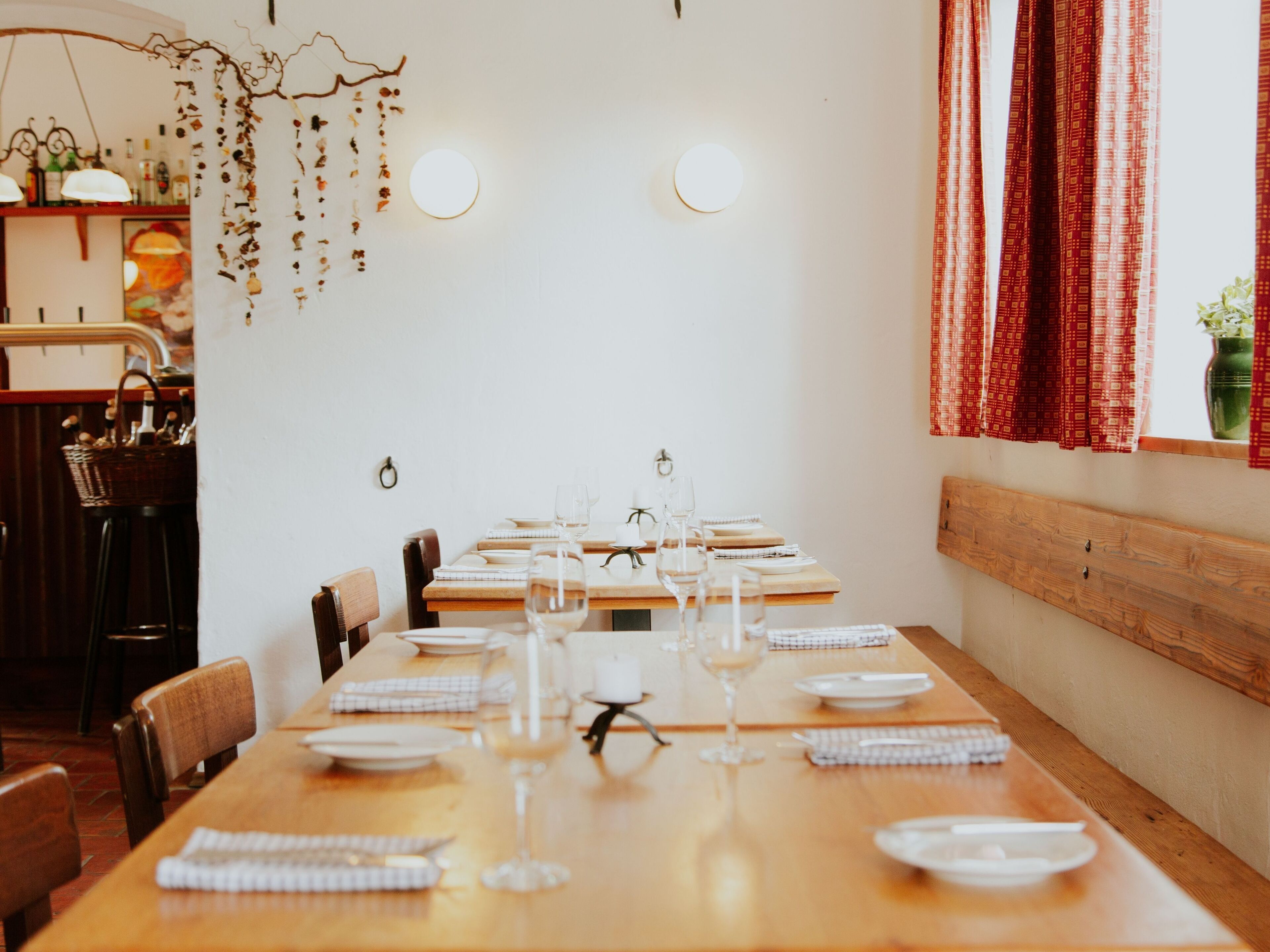 Comedor con una larga mesa de madera dispuesta para una comida, rodeado de sillas.