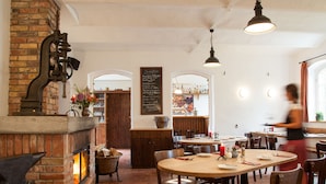 A restaurant with brick walls, a fireplace, wooden tables, and chairs. - Landhaus Alte Schmiede (Niemegk)