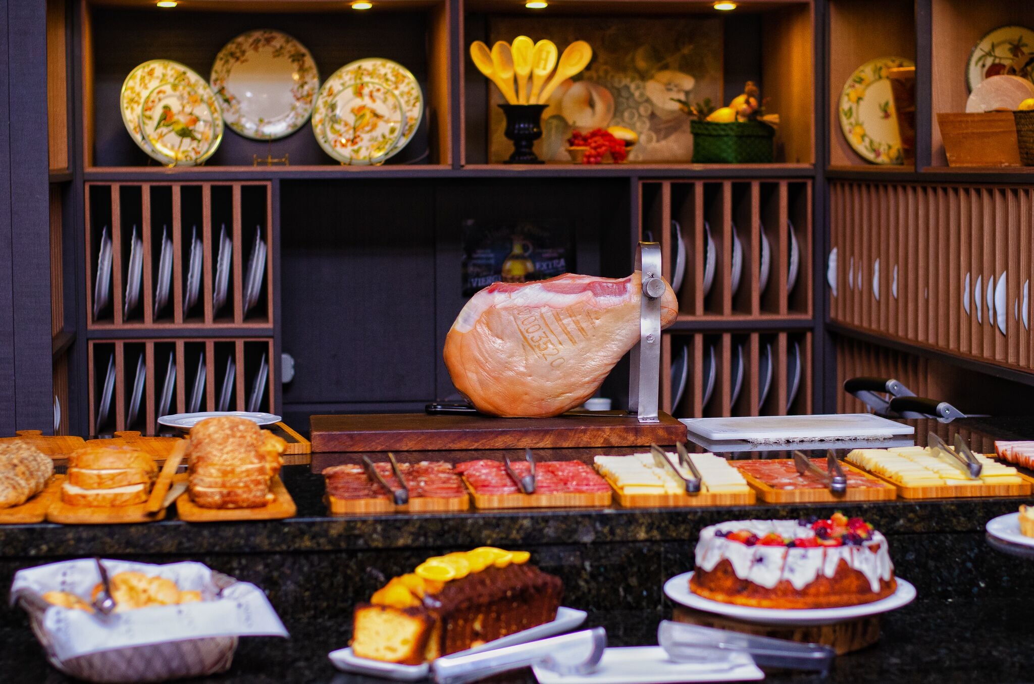 A buffet with various food items, including cakes and pastries, arranged on a counter.