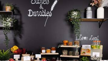 A display of local products and a sign reading 'Des habitudes Saines & Durables' with a 'Love Local' slogan.