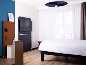 A hotel room with a bed, a TV, a small table, and a chair. - ibis Valenciennes (Valenciennes)