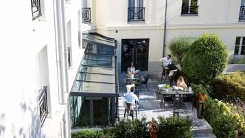 Une cour dotée d’un espace extérieur aménagé pour s’asseoir, d’un escalier et d’un jardin bien entretenu.