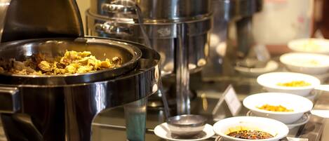 Una mesa de buffet con diferentes platos y utensilios.