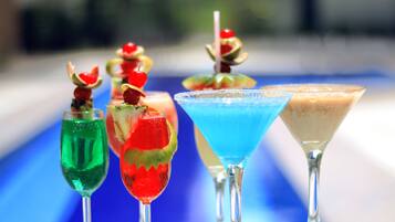 Eine Reihe bunter Cocktails mit Garnitur, serviert in Martini-Gläsern.