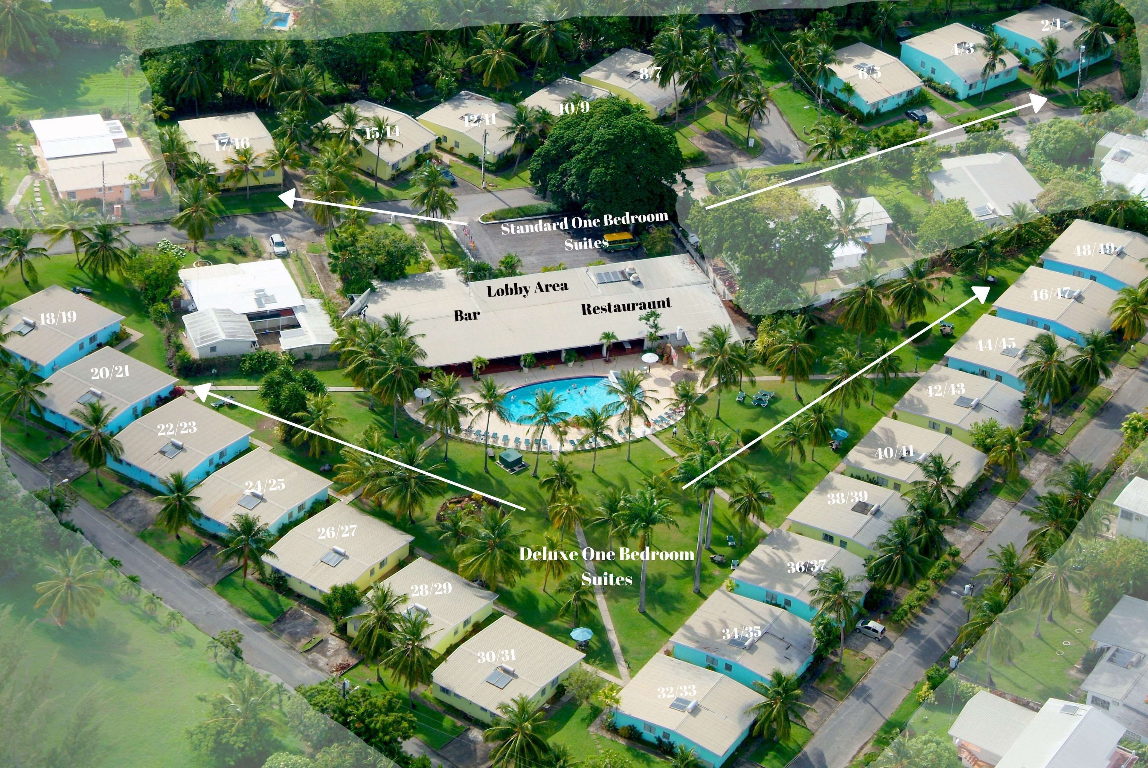 Eine Luftaufnahme eines Resorts mit Standard- und Deluxe-Ein-Zimmer-Suiten, einer Bar, einem Restaurant und einem Poolbereich.