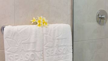 A white towel with embossed text and a flower on a rack.