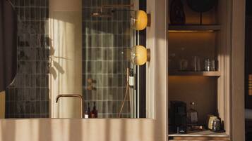 Une salle de bain avec un miroir, un porte-serviettes, une douche et une étagère contenant des articles de toilette.