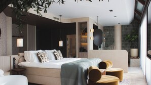 Quarto moderno com uma cama grande, mesas de cabeceira, um espaço de estar com pufes e um guarda-roupa embutido.