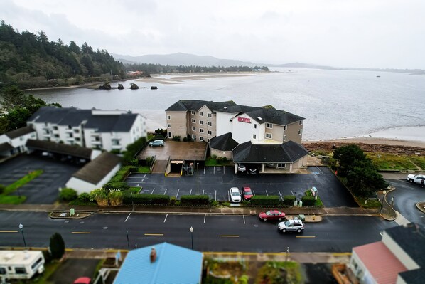 Um motel com estacionamento e vista para a praia.