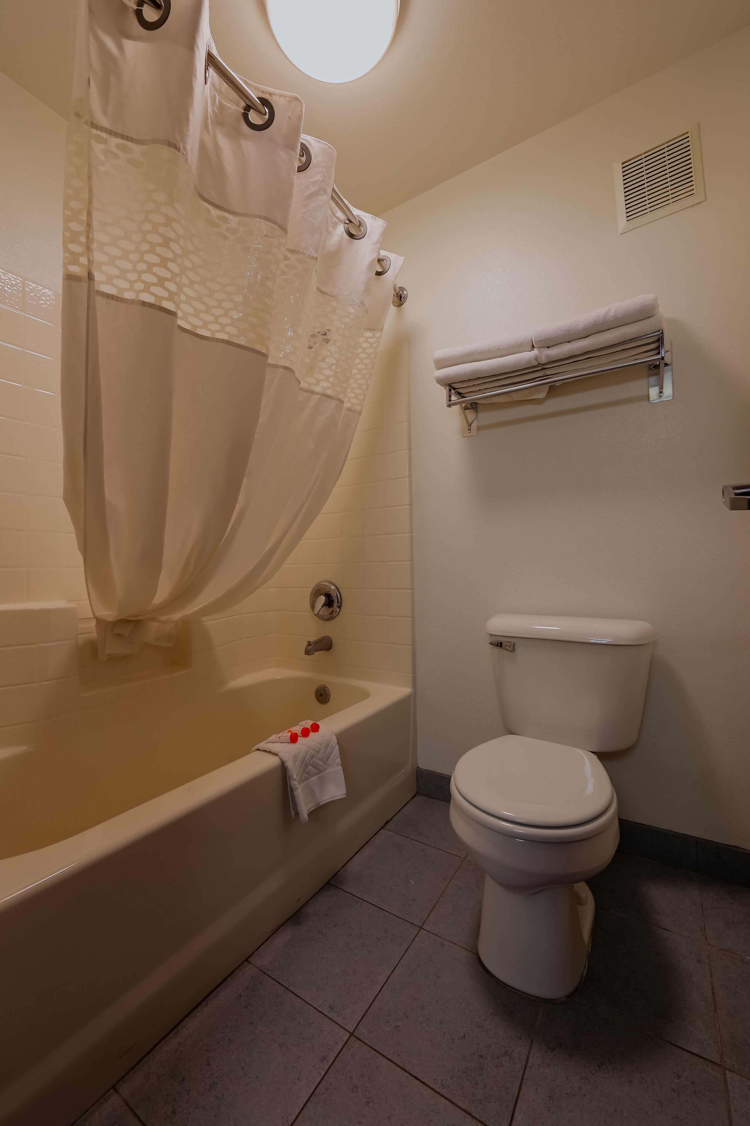 A bathroom with a bathtub, toilet, and towel rack.