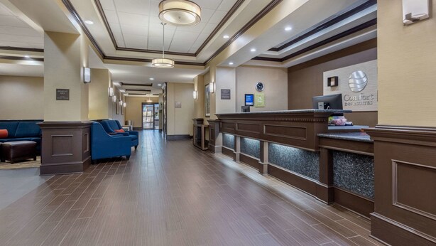 A hotel lobby with a reception desk, seating area, and a sign indicating the breakfast area. - Comfort Inn & Suites North Little Rock McCain Mall (North Little Rock)
