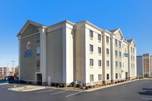 A Comfort Inn hotel with a modern design, featuring a large parking lot and a clear blue sky. - Comfort Inn & Suites North Little Rock McCain Mall (North Little Rock)