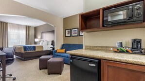 A hotel room with a bed, a sofa, a desk, a refrigerator, a microwave, and a coffee maker. - Comfort Inn & Suites North Little Rock McCain Mall (North Little Rock)