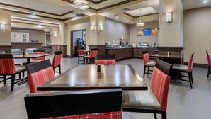 A spacious restaurant with high ceilings, multiple dining tables, and red upholstered chairs. - Comfort Inn & Suites North Little Rock McCain Mall (North Little Rock)