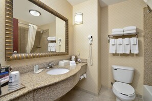 A hotel bathroom with a granite countertop sink, a large mirror, a towel rack, a toilet, and a hairdryer. - Comfort Inn & Suites North Little Rock McCain Mall (North Little Rock)