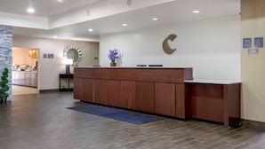 A reception area with a wooden counter, a large C-shaped sign, and a potted plant. - Comfort Suites Copperas Cove (Copperas Cove)